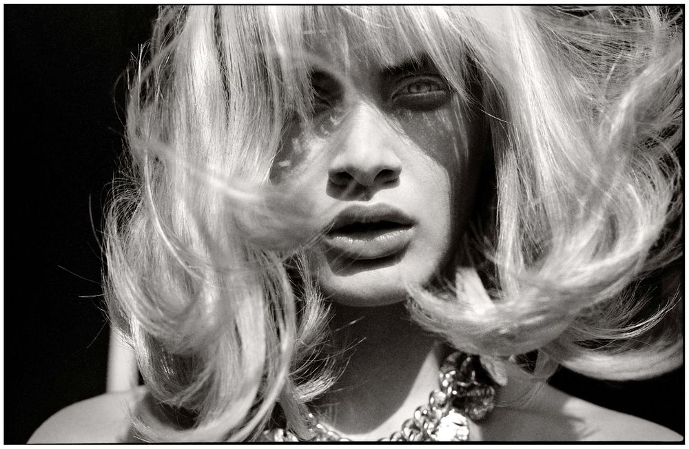 A black and white artistic fashion photo series showing dramatic close-up portraits with flowing blonde hair.