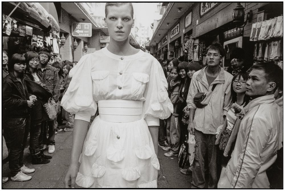 Vintage black and white photographs showing busy street scenes and storefronts in an urban setting.