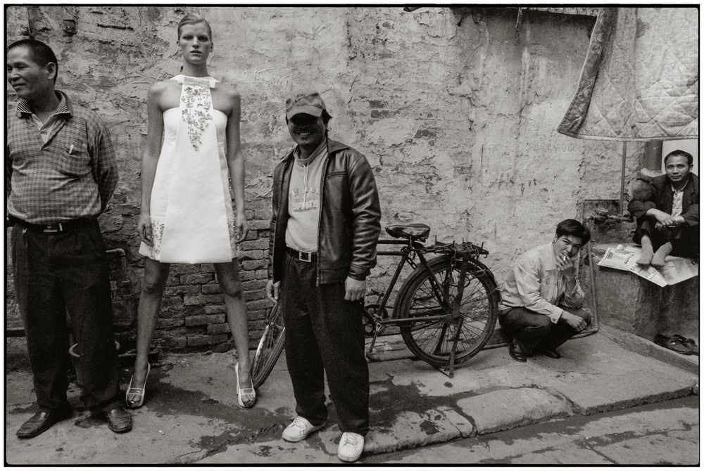 A series of black and white street photographs showing people and bicycles against weathered stone walls.