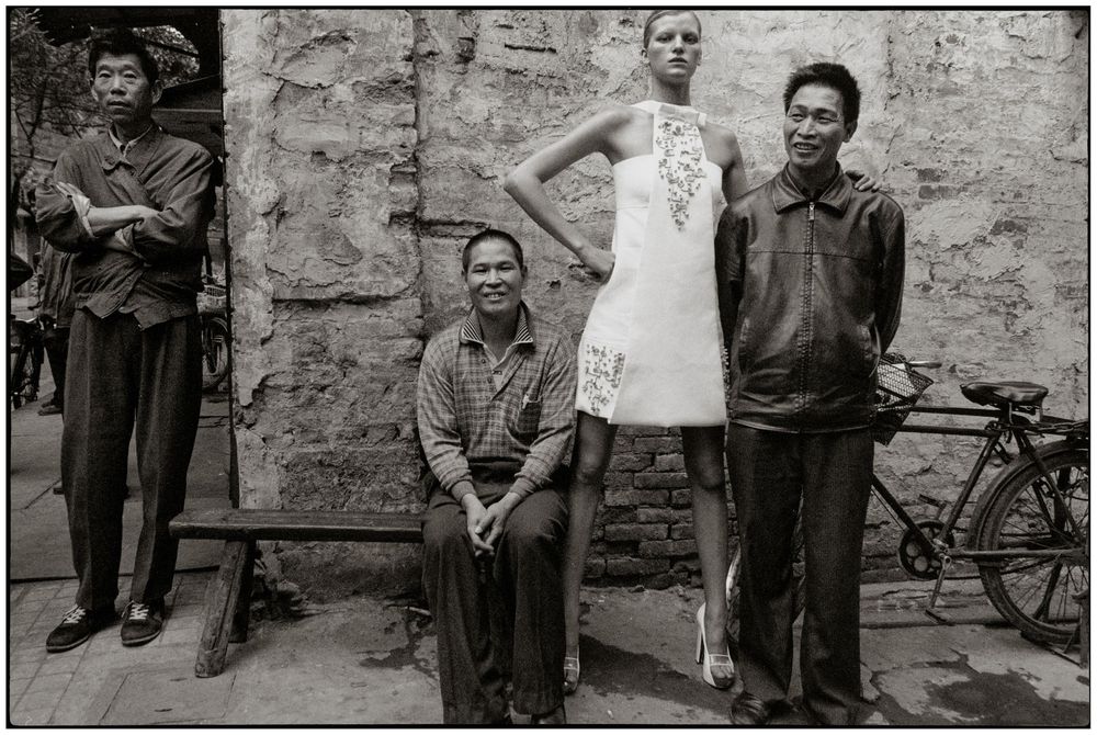 A series of vintage black and white photographs showing people standing against stone walls in a documentary style.