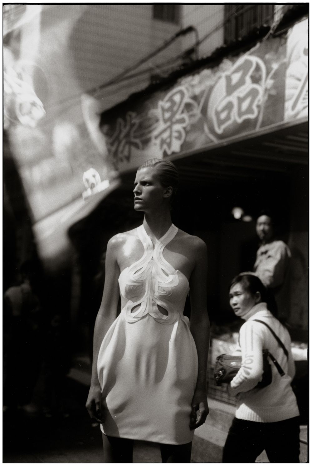 A series of black and white photographs showing figures in white tops against dark backgrounds.