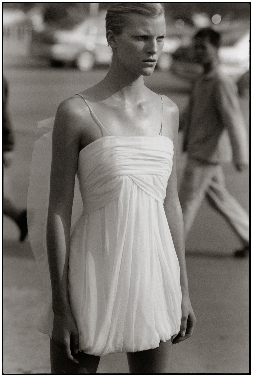 A series of black and white fashion photographs showing a flowing white summer dress against a blurred background.