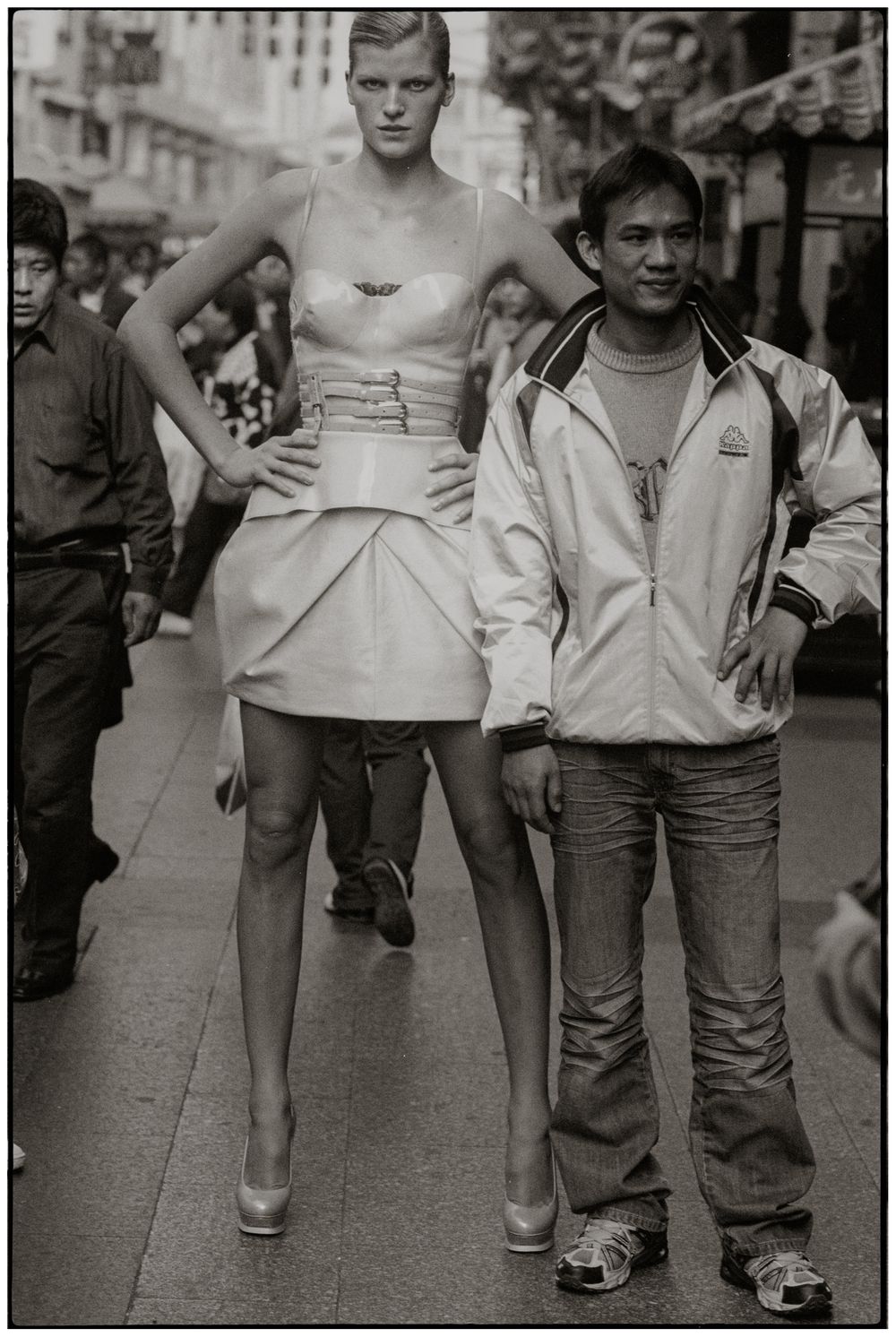 Black and white photograph showing a series of cropped street scenes focusing on people's legs and feet on a sidewalk.