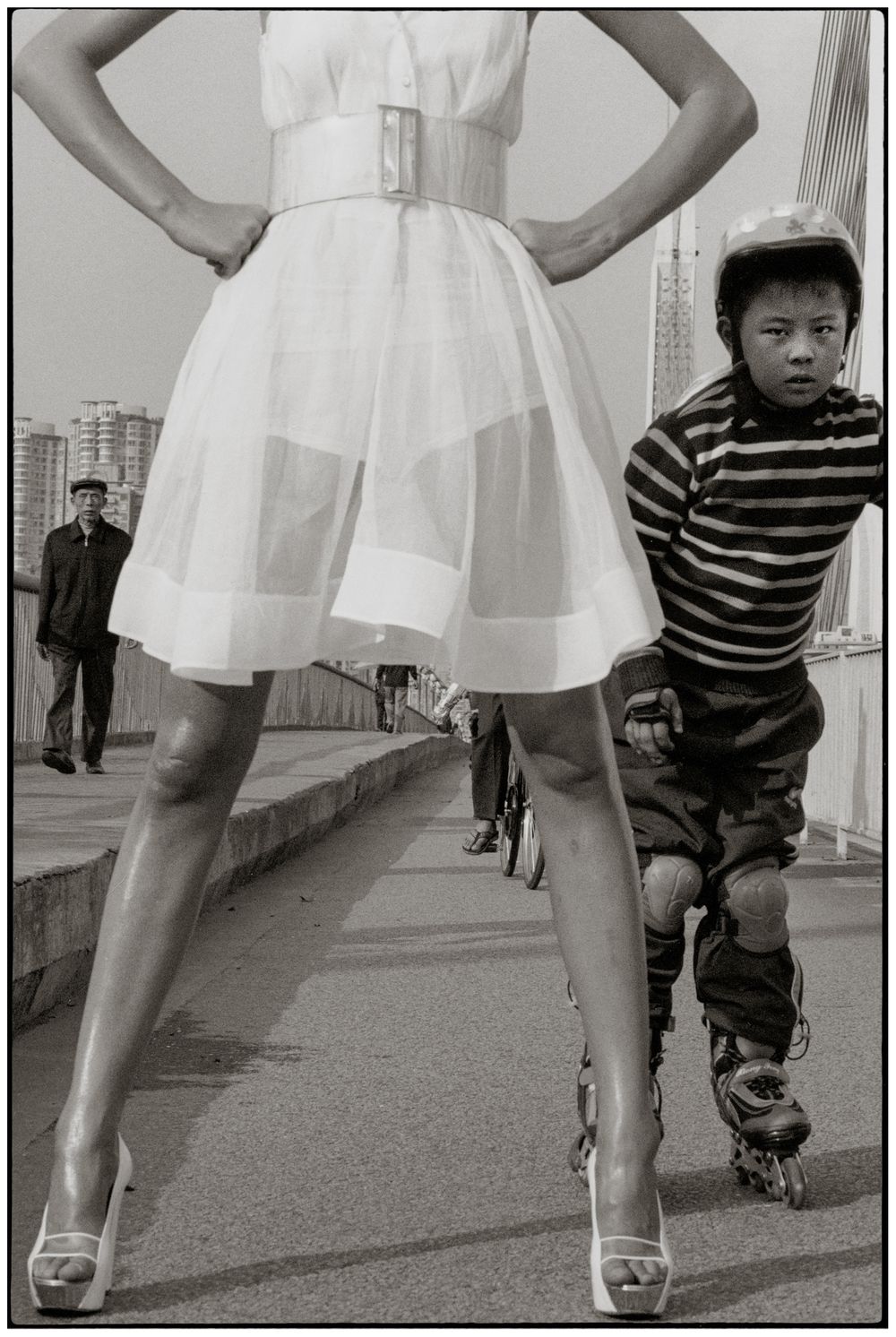 A sequence of black and white photos showing a child in stripes playfully following behind someone in a white dress.