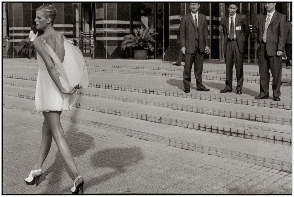 A series of black and white photographs showing people walking down a staircase in a formal setting.