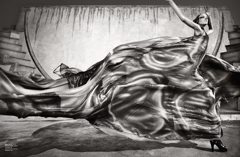 Black and white panoramic sequence showing a figure running through abstract flowing shapes and patterns.
