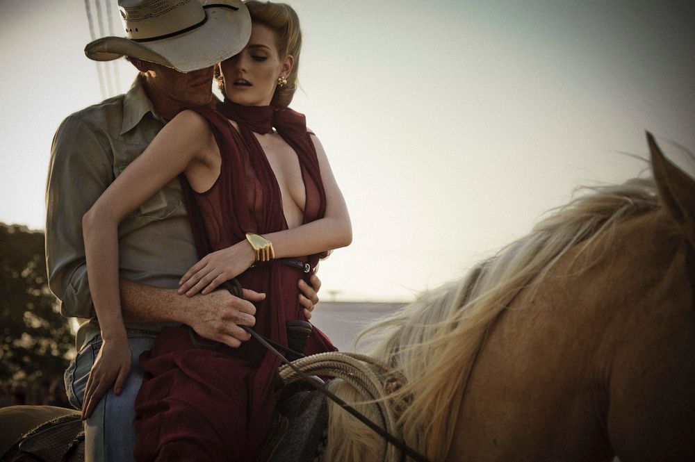 A romantic couple embraces during a golden sunset photoshoot in an outdoor setting.