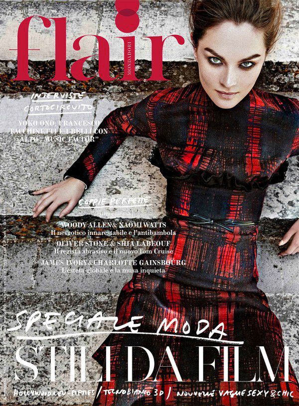 Fashion editorial spread featuring moody black and red styling against textured concrete background.