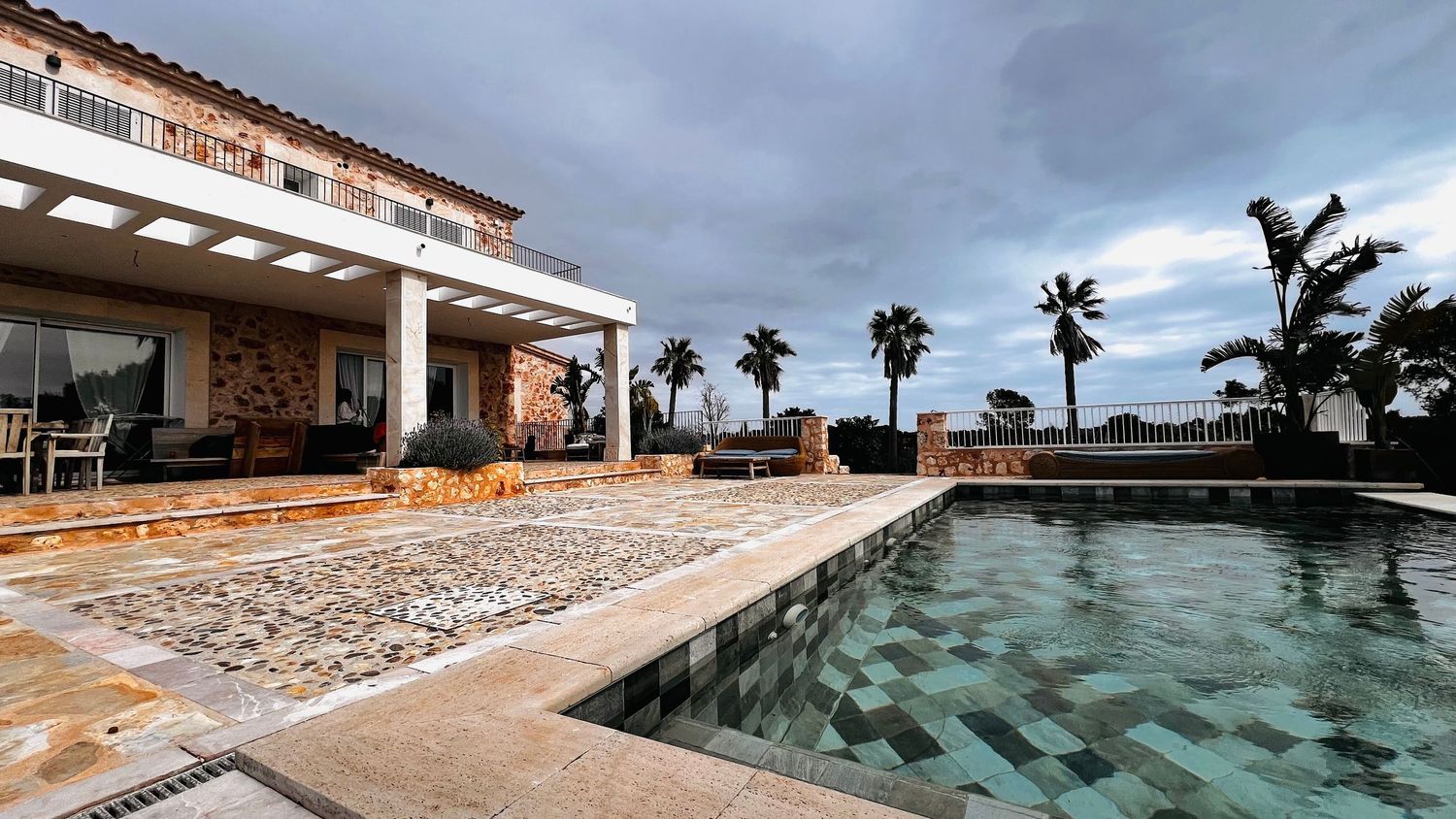 Stunning coastal villa development overlooking Mediterranean Sea during golden sunset with mountains in background.