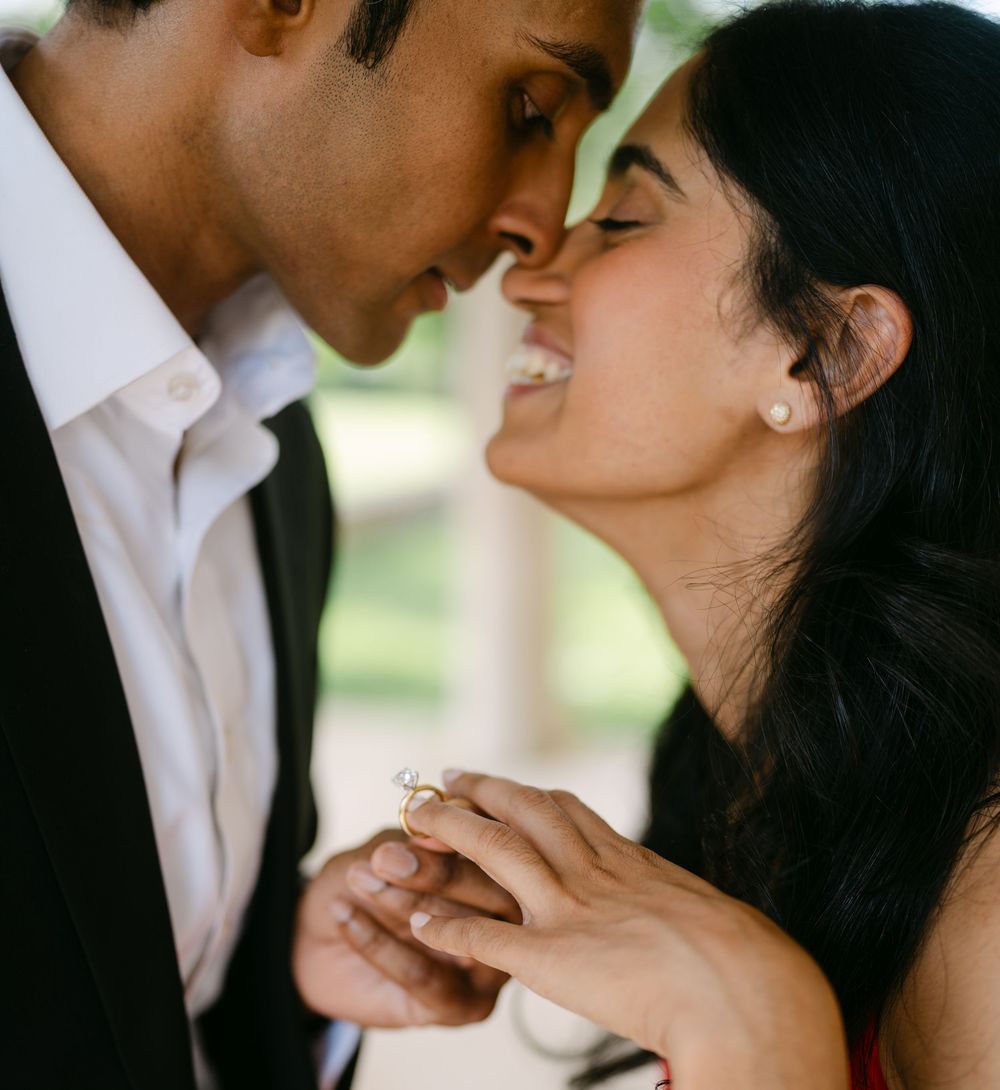 A romantic close-up moment between a couple showing an engagement ring.