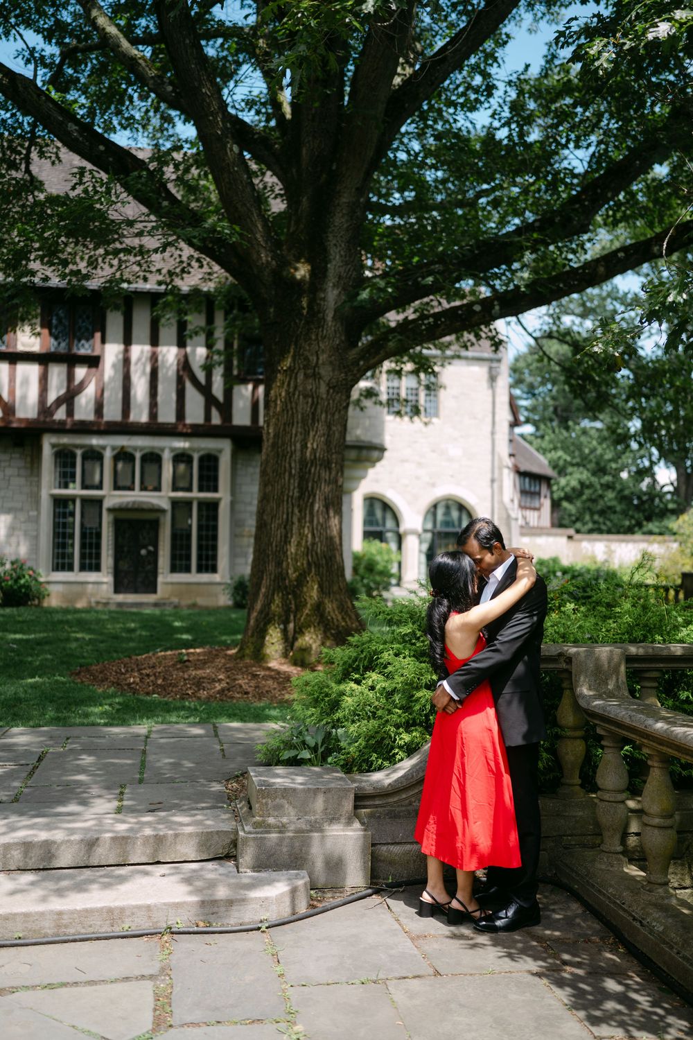 A series of romantic photos showing a couple embracing against a stone Tudor-style building with large windows and trees.