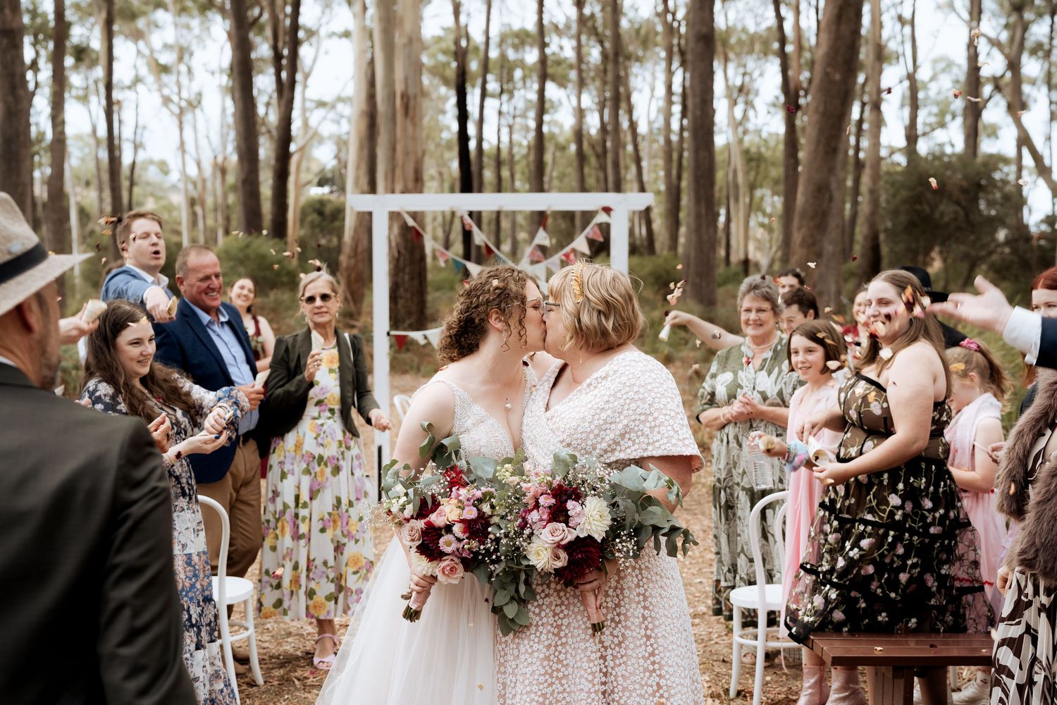 Intimate wedding portrait against a tree with soft natural lighting.