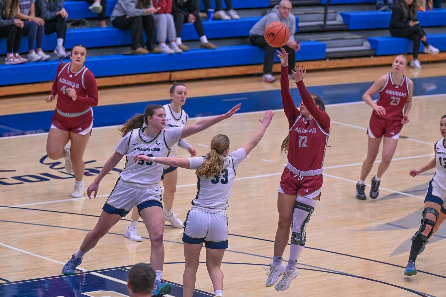 Emily Cline shooting a fade away shot over two defenders, Aquinas vs Cornerstone, Bernice Hansen Athletic Center , Grand Rapids MI, 2/19/25