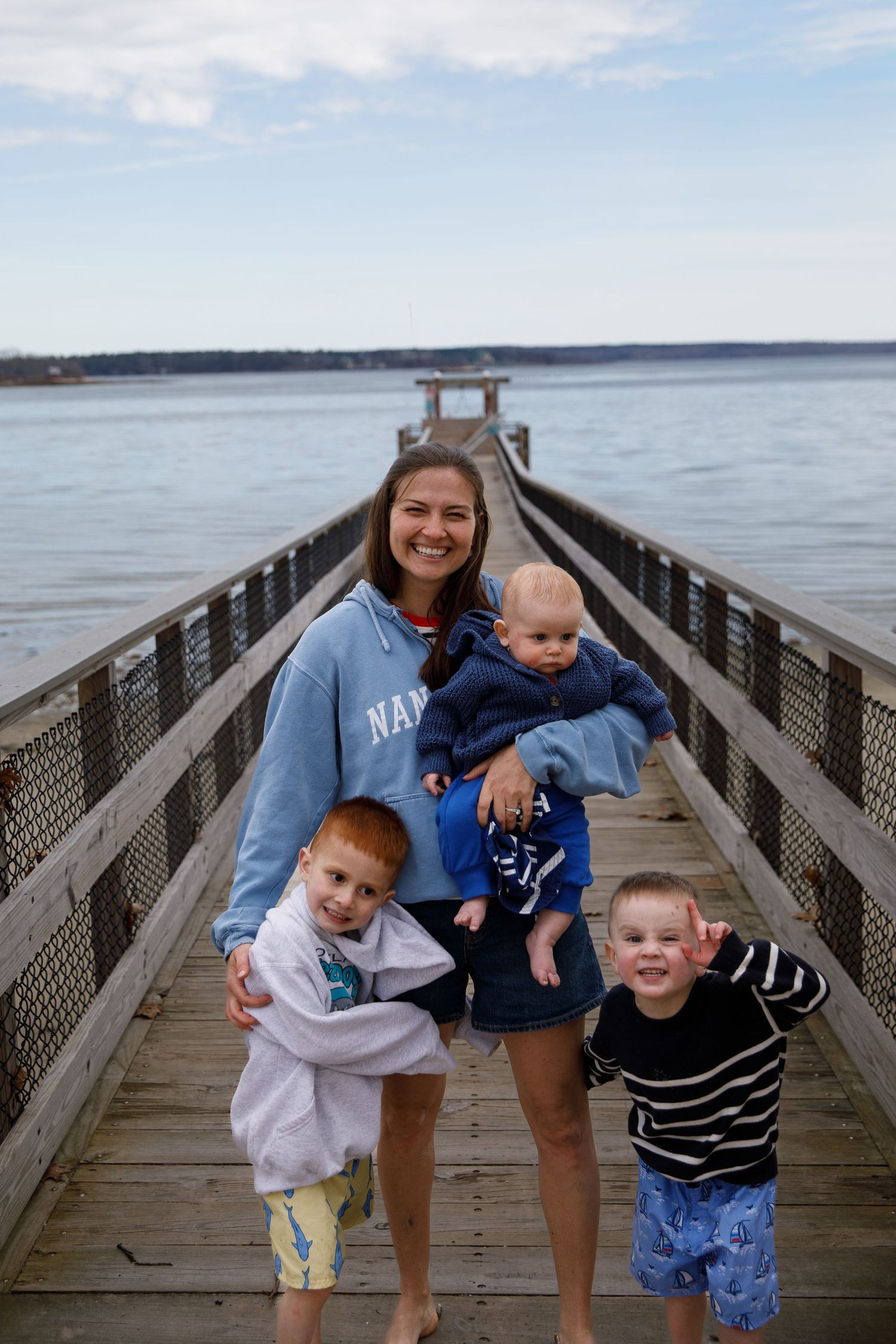 Portrait photograph of a young family smiling on a Maine beach in the summertime. A handsome man, his wife, and two beautiful toddlers.