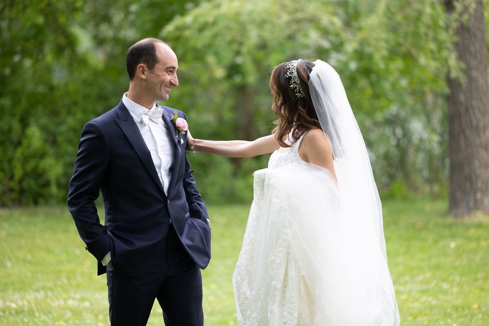 Newlyweds share a joyful moment together in a verdant, outdoor garden setting.