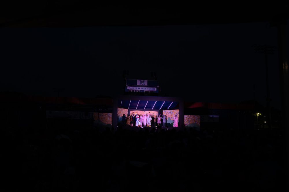 Purple-lit stage building illuminated at night during an outdoor event.