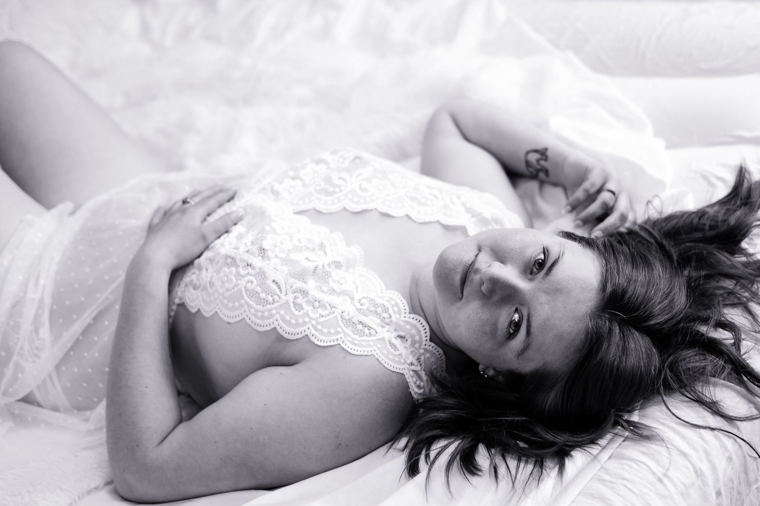 Black and white photographs arranged in a horizontal strip show intimate boudoir poses with romantic lighting and composition.