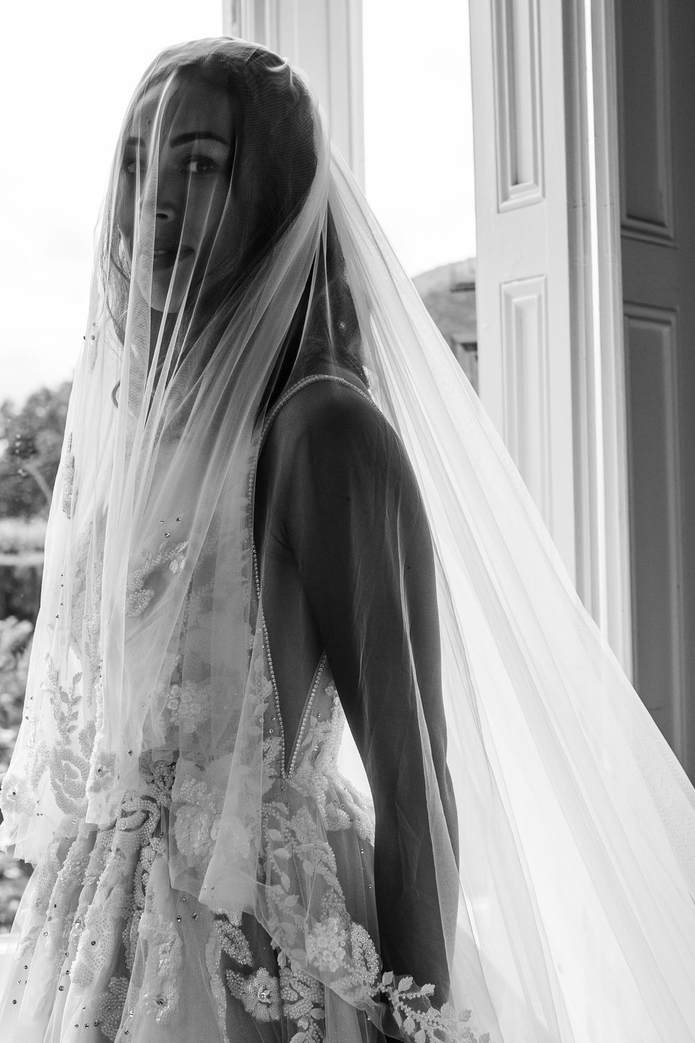 Ethereal bridal portrait series showing flowing veil details in dramatic black and white photography.