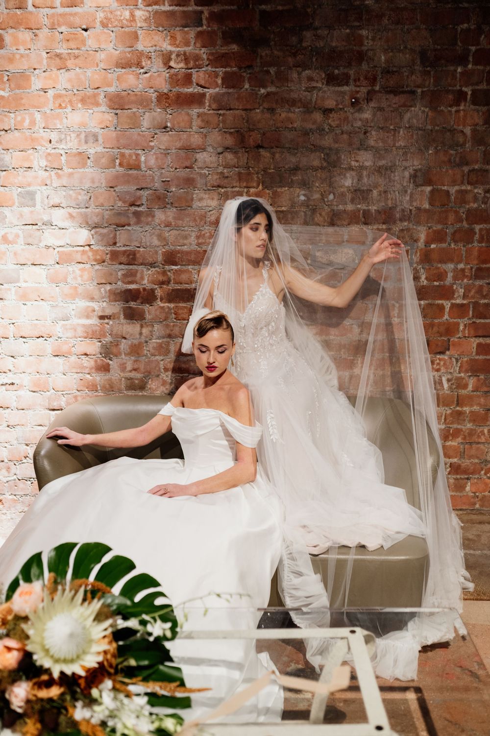 A series of photographs showing a bride in a white wedding dress reclining on a vintage sofa against a brick wall.
