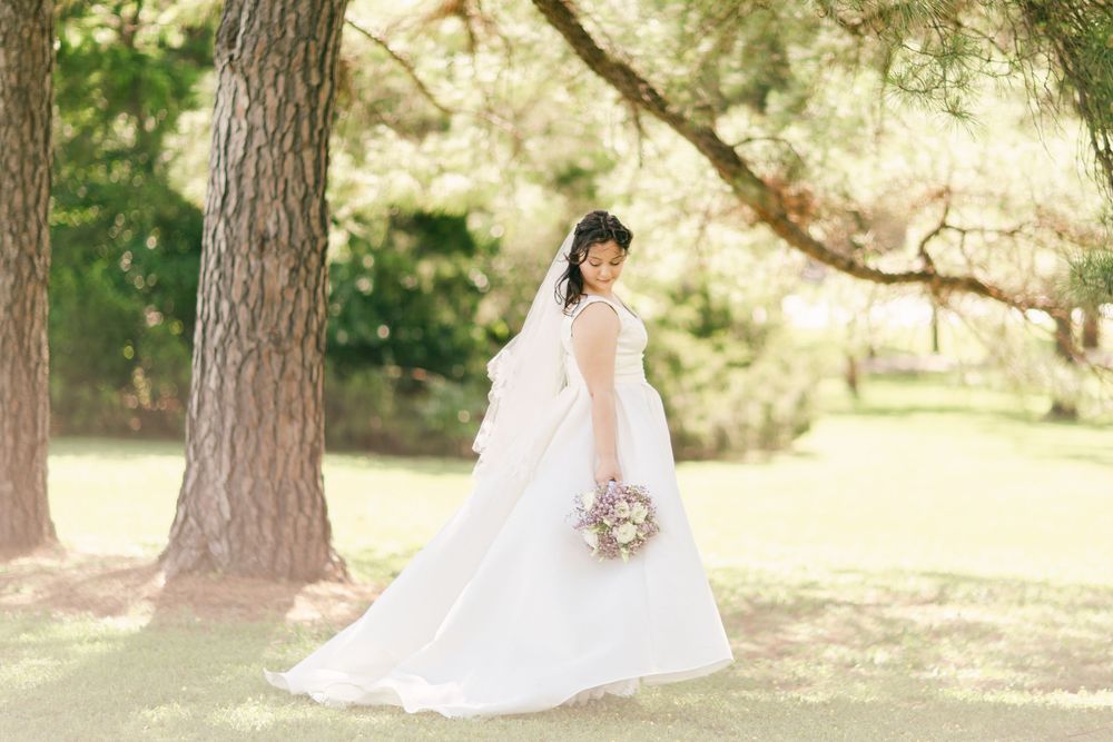 Elegant bridal portrait under tall pine trees in a natural outdoor setting.