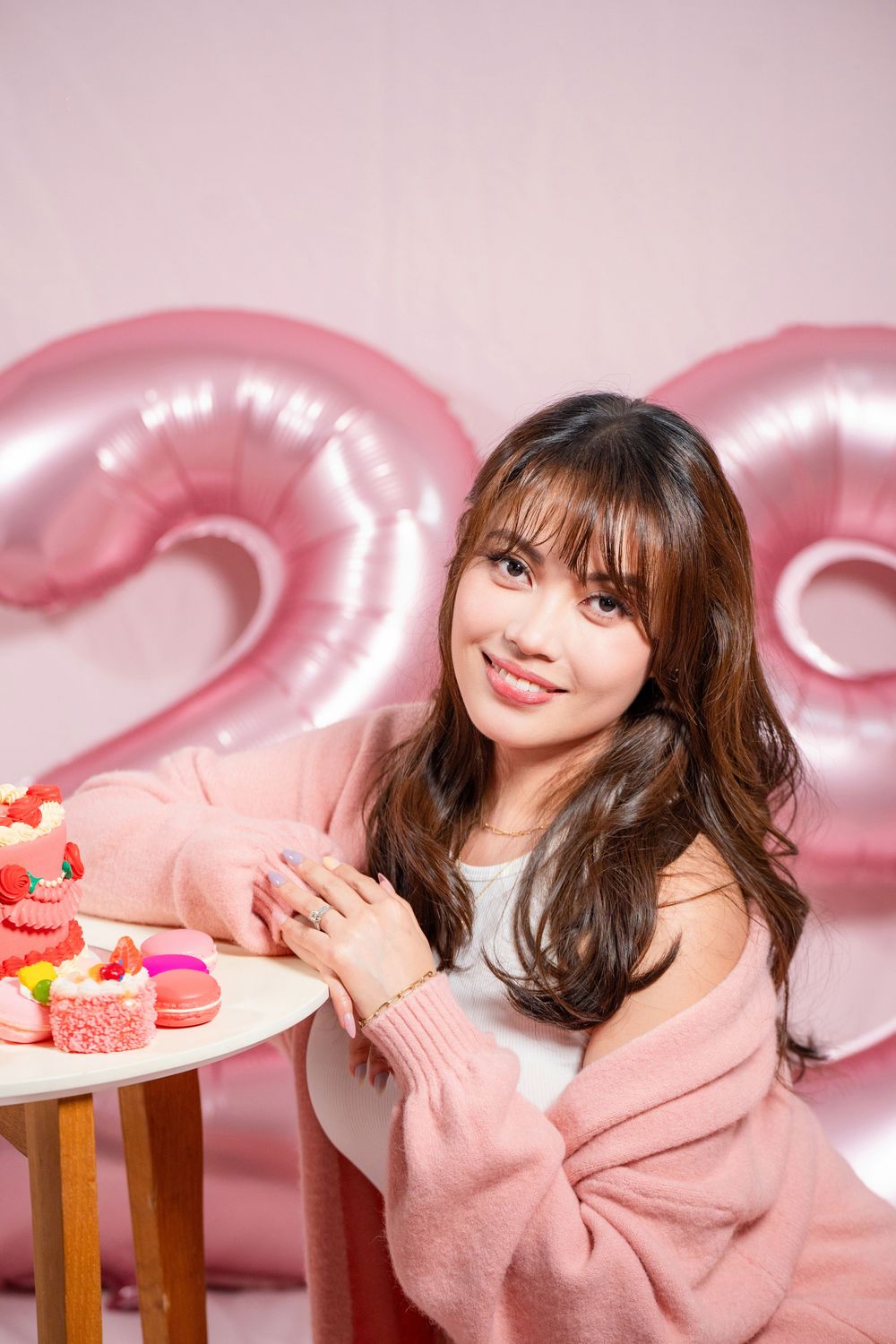 Fun and vibrant indoor 20th birthday studio portrait shot on a pink seamless backdrop by a professional Auckland portrait photographer.