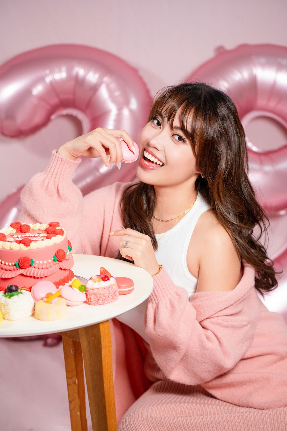 Fun and vibrant indoor 20th birthday studio portrait shot on a pink seamless backdrop by a professional Auckland portrait photographer.