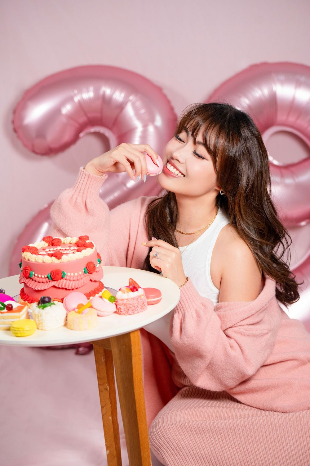 Fun and vibrant indoor 20th birthday studio portrait shot on a pink seamless backdrop by a professional Auckland portrait photographer.