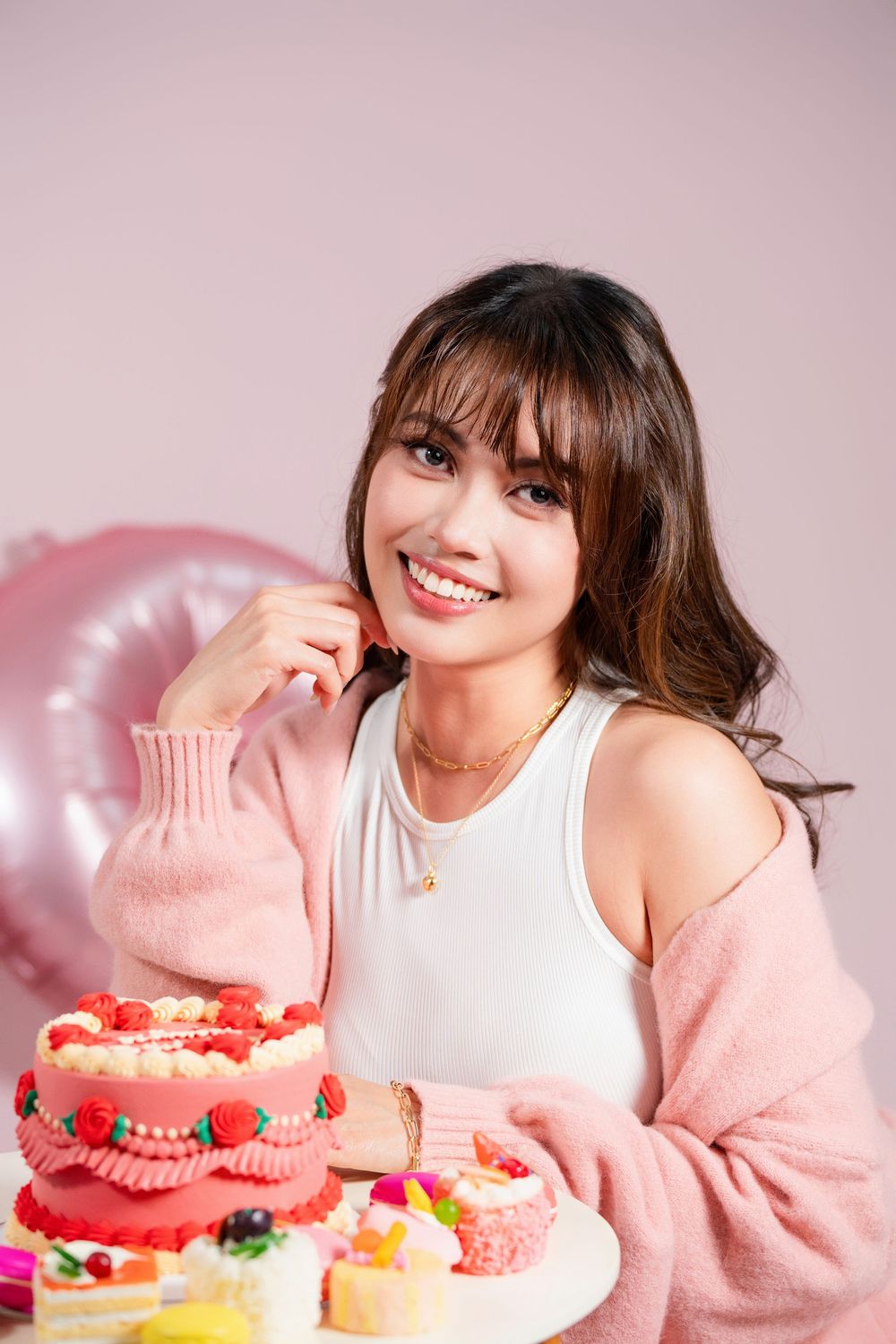 Fun and vibrant indoor 20th birthday studio portrait shot on a pink seamless backdrop by a professional Auckland portrait photographer.