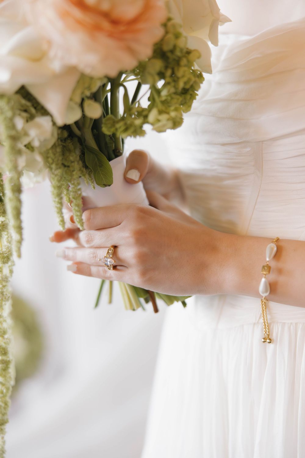 A series of close-up shots showing a white-gowned person's hands wearing an elegant engagement ring and wedding band.