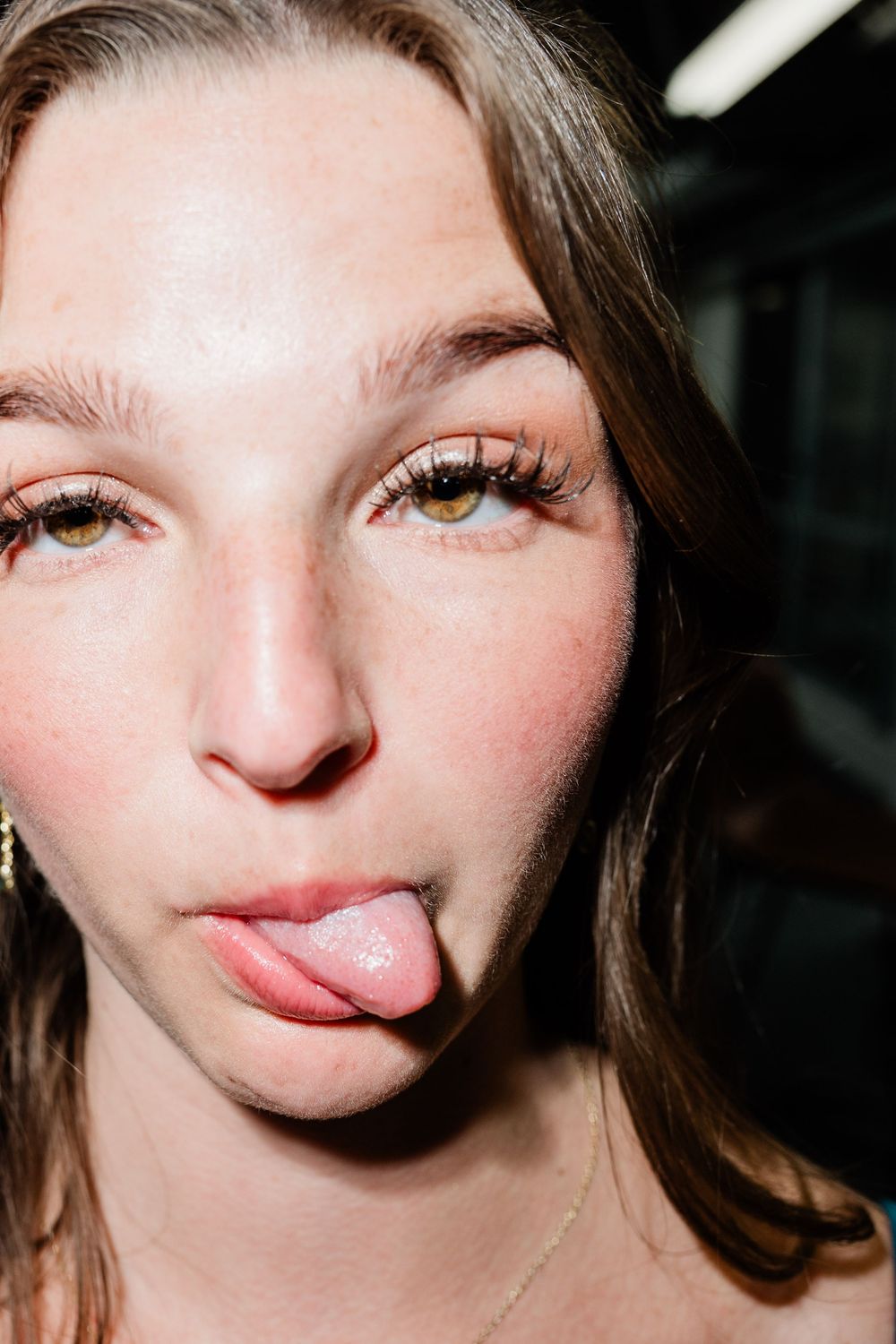 Close up beauty shot with shimmery makeup and playful expression.