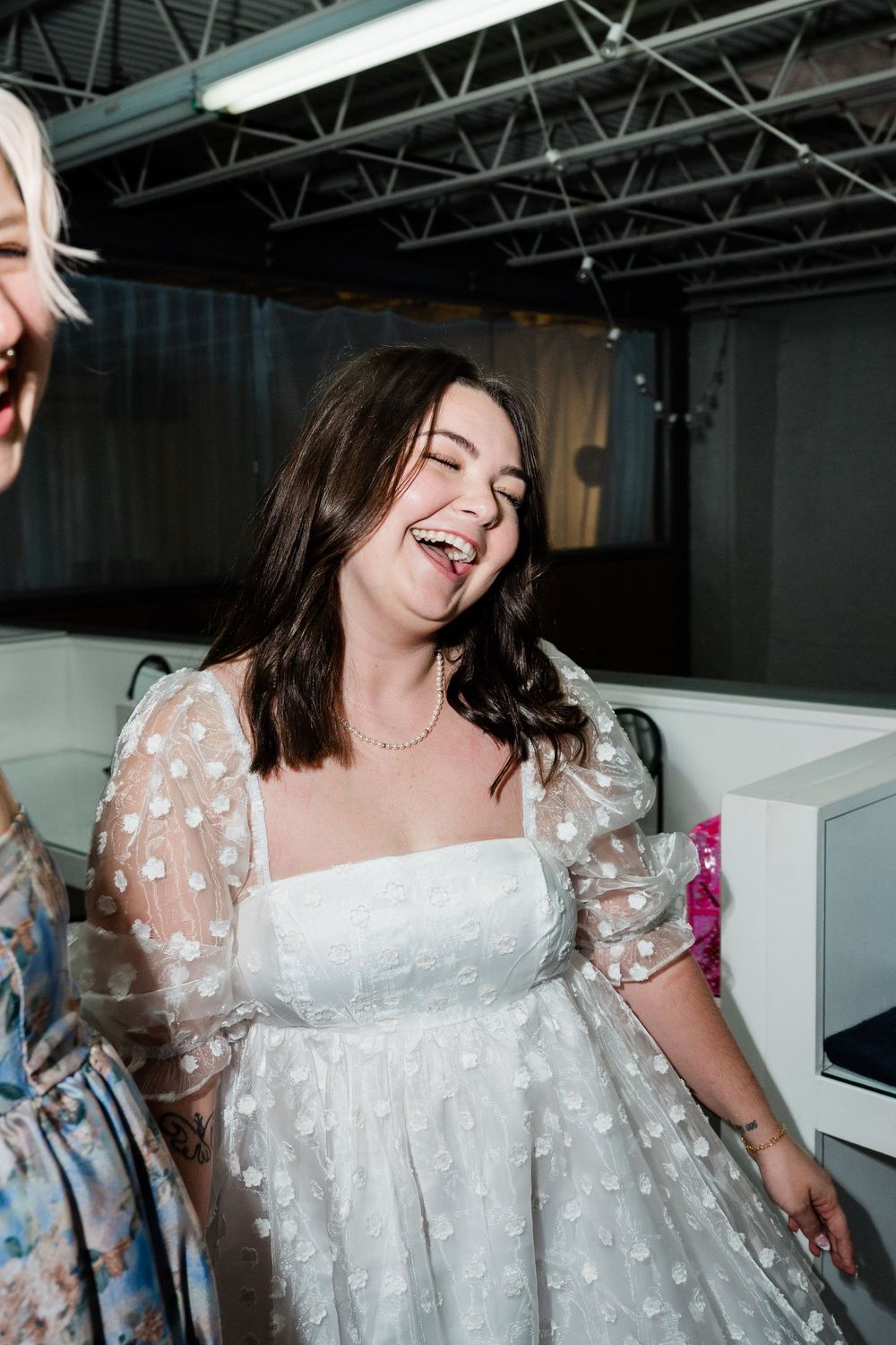 A joyous moment captured in a white polka dot wedding dress with sheer puff sleeves.