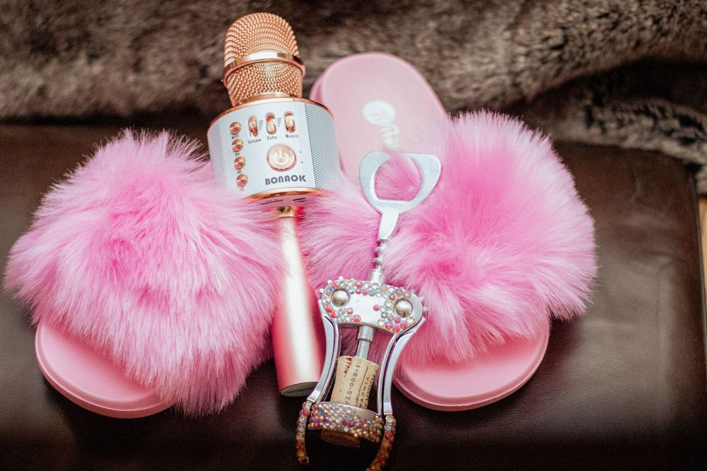 Pink fur pom pom sandals lined up in a row with sparkling crystal embellishments for glamorous footwear.