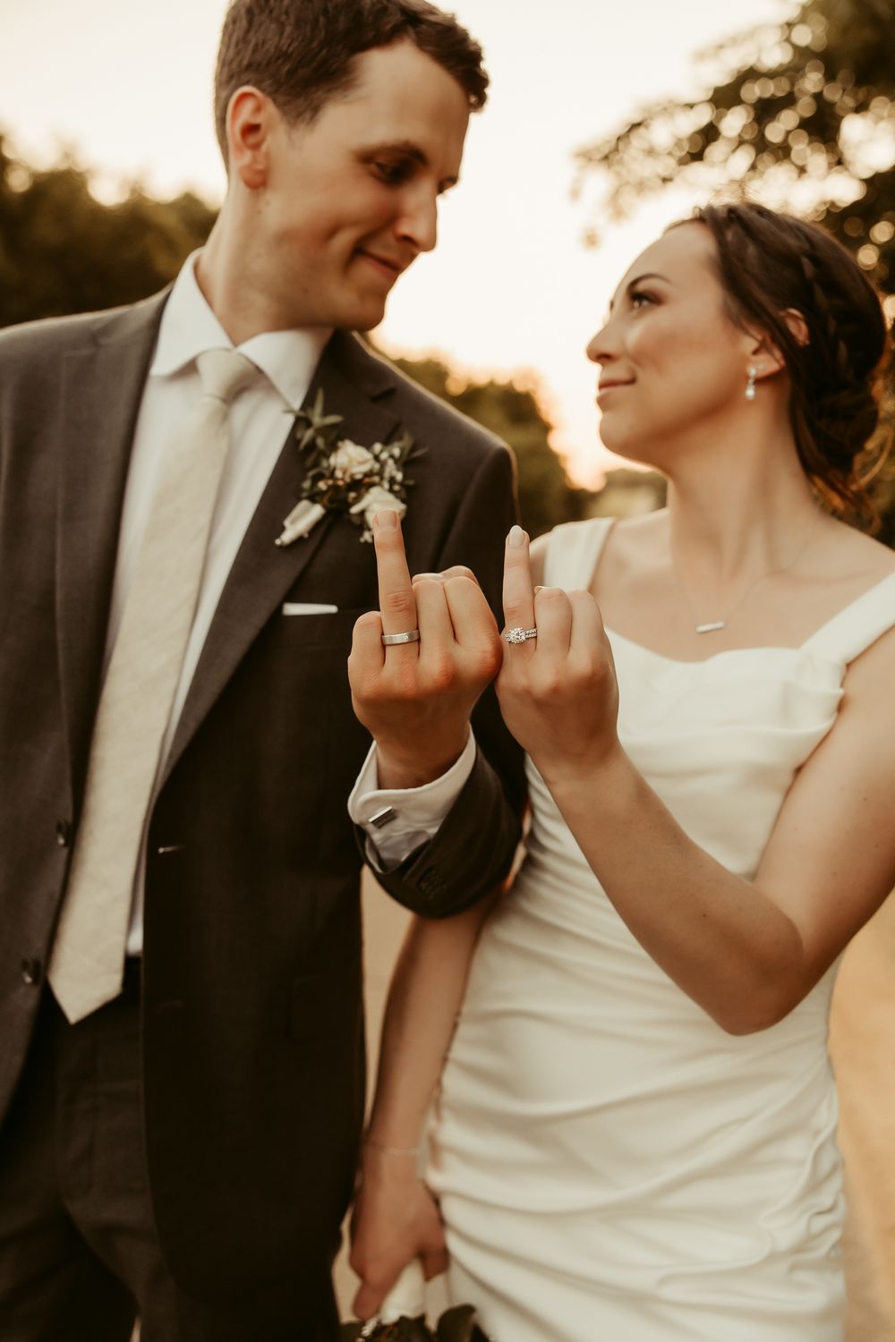 A romantic wedding series showing a couple playfully displaying their rings at sunset in elegant formalwear Cottage Grove Minnesota