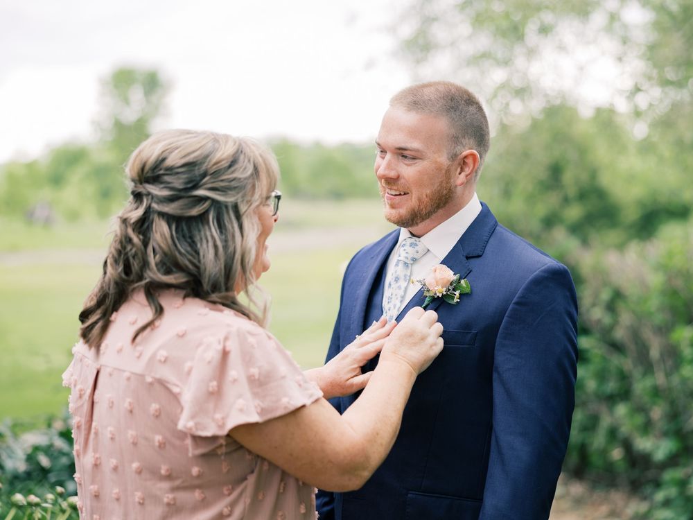 A couple shares an intimate moment during their wedding day outdoors at a sunny venue.