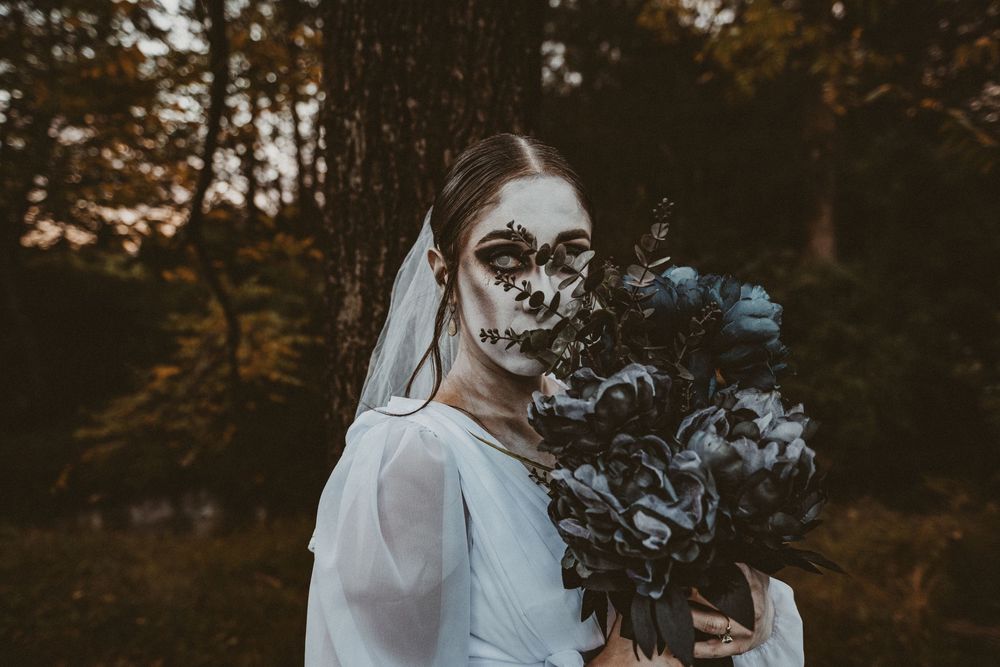 Artistic bridal portrait with dramatic smoke effect in moody forest setting at sunset.