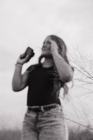 An artistic black and white series showing a photographer in motion against grass silhouettes.