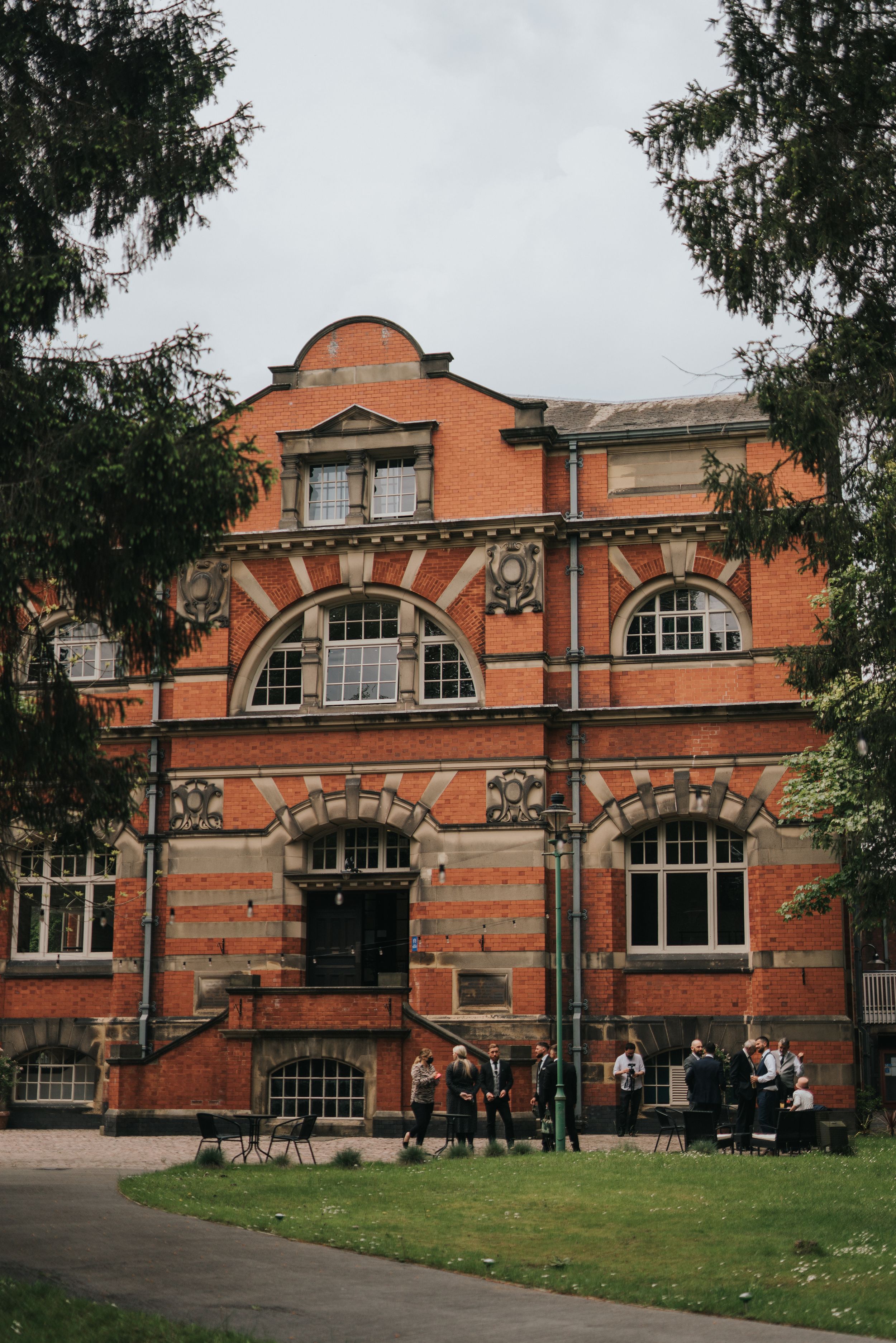 Historic red brick building with ornate Victorian architecture features arched windows and decorative stonework on its facade.