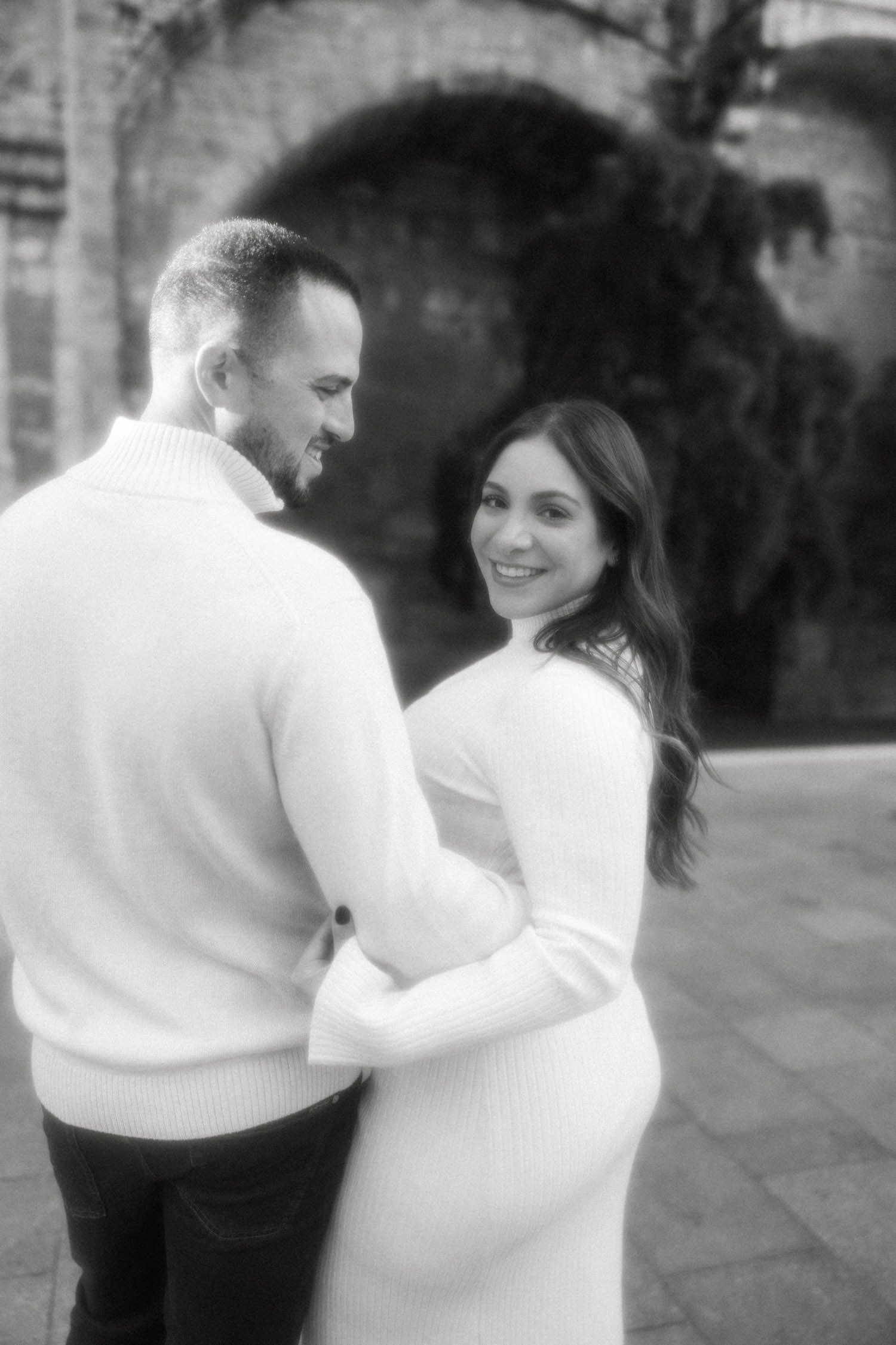 Black and white romantic maternity portraits against stone architecture.