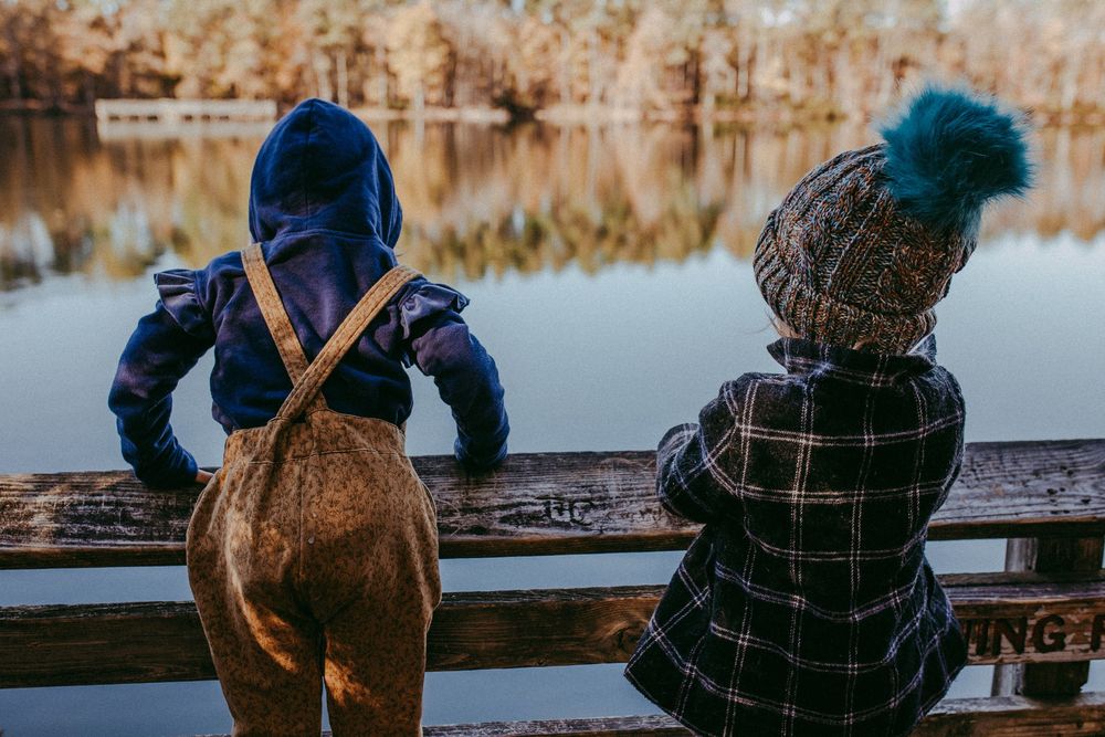 Two little girls play on lake dock in winter gear. Whitney Popp, Arizona photographer