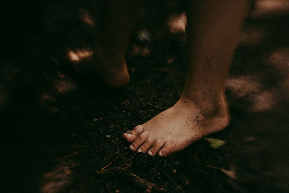 Bare feet walking on dark soil or dirt ground in moody lighting. Whitney Popp, Arizona photographer