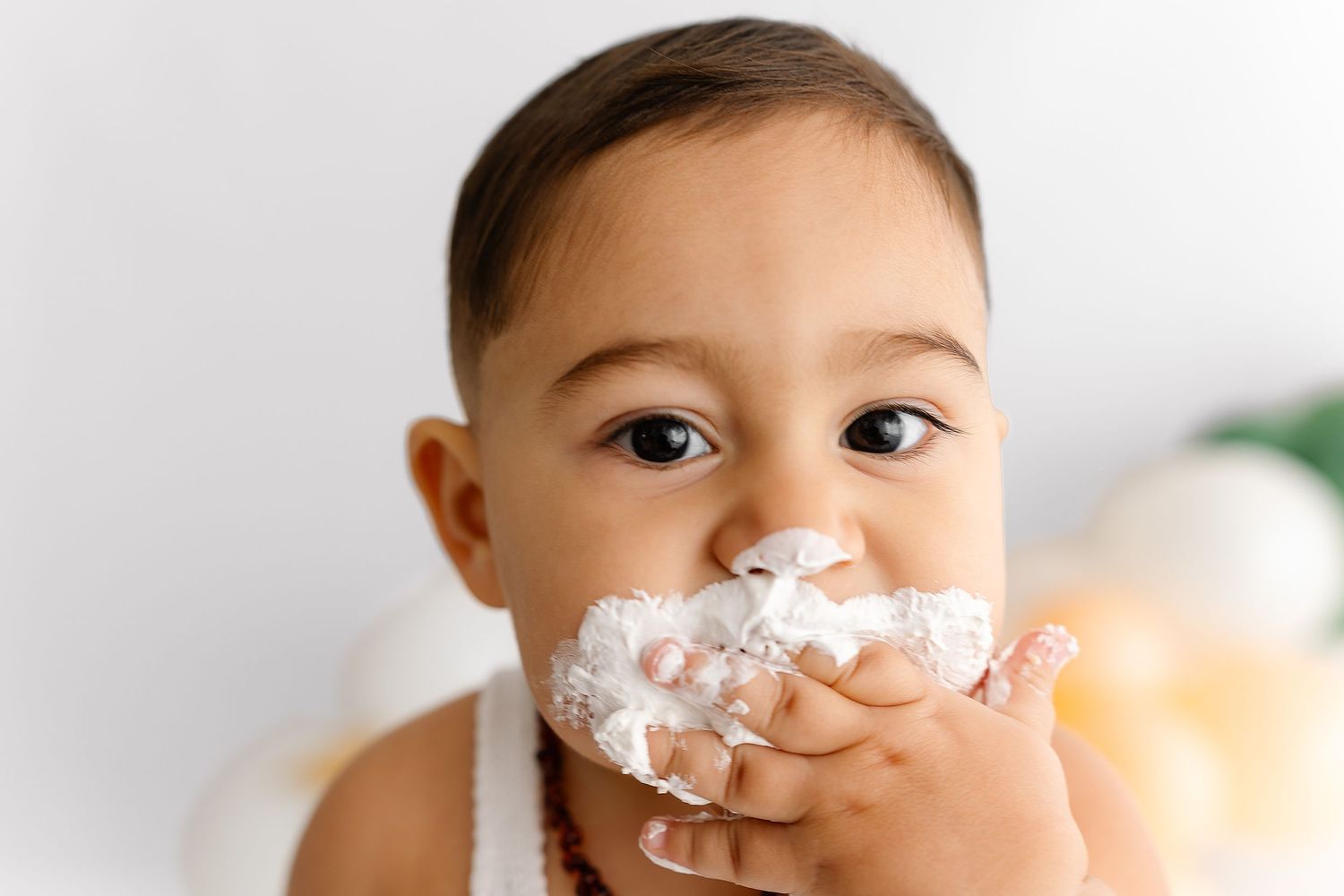 Toddler playing with whipped cream showing different facial expressions across four photos arranged side by side.