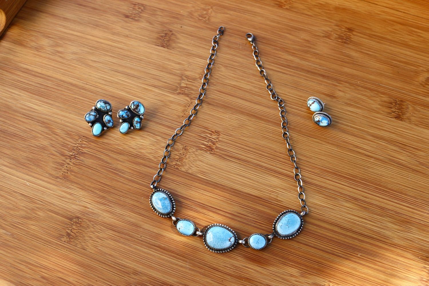 Close-up of a custom turquoise and silver choker necklace by NK Silver Co. on a rustic wooden background.