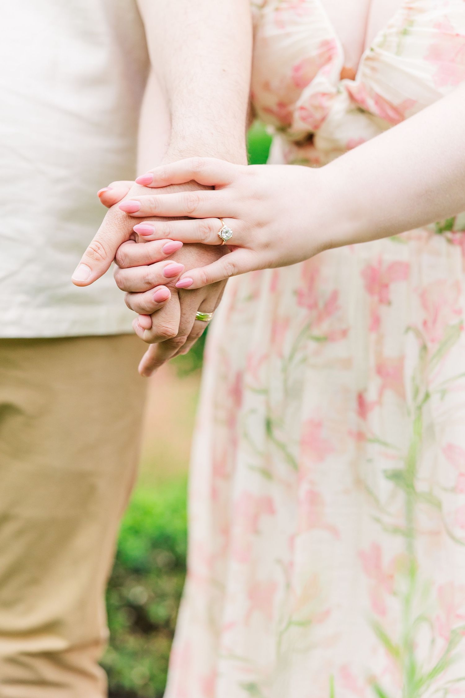 A close-up sequence showing hands with rings holding each other against a floral dress background.