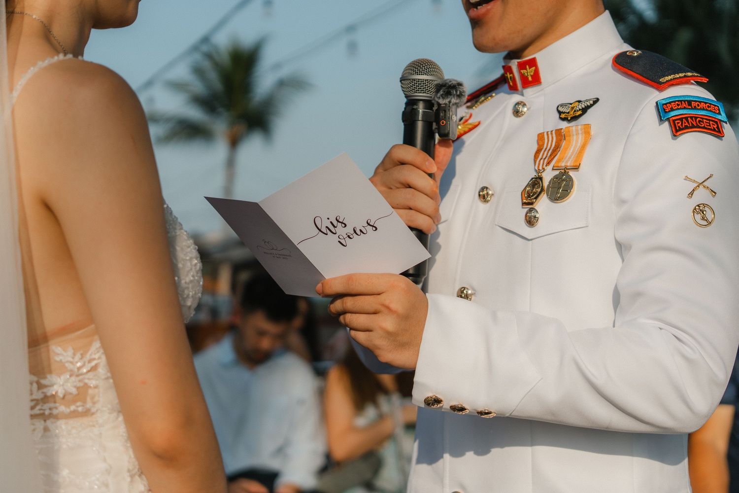 Close-up of wedding vows being read during outdoor ceremony.