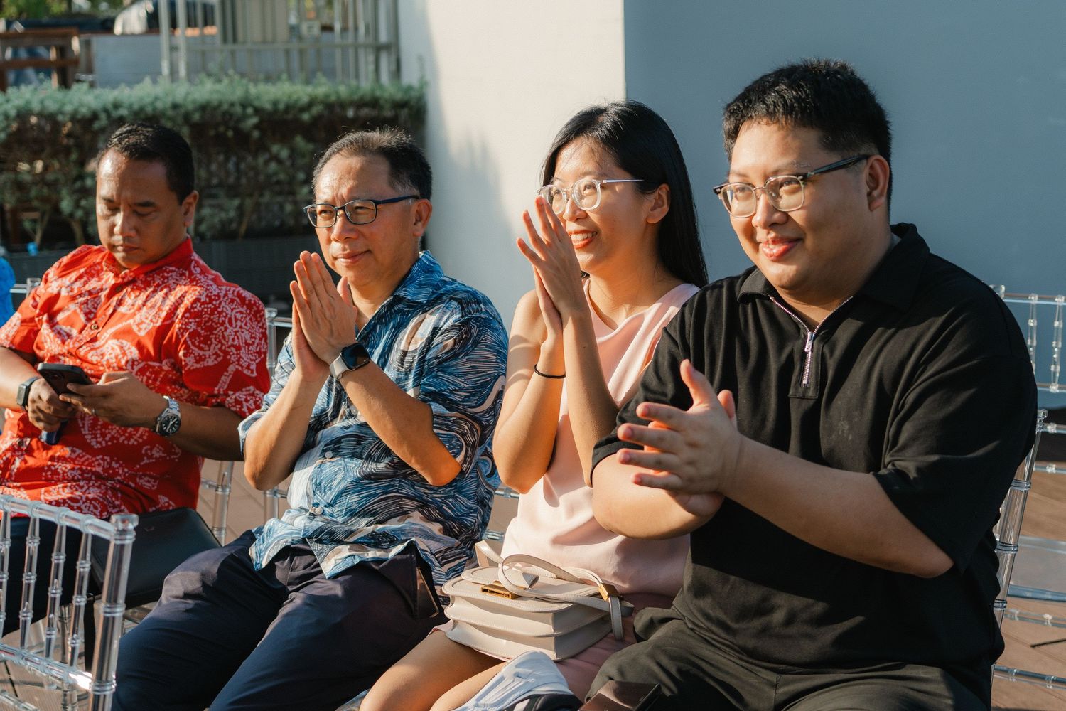Wedding guests watching ceremony and reacting emotionally during outdoor celebration.