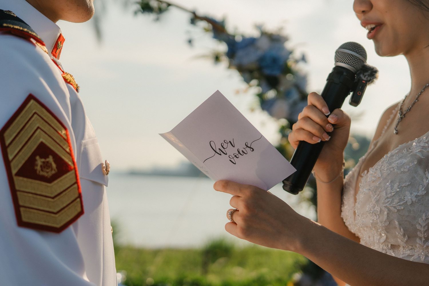 Wedding ceremony details with rings and documents being exchanged outdoors.
