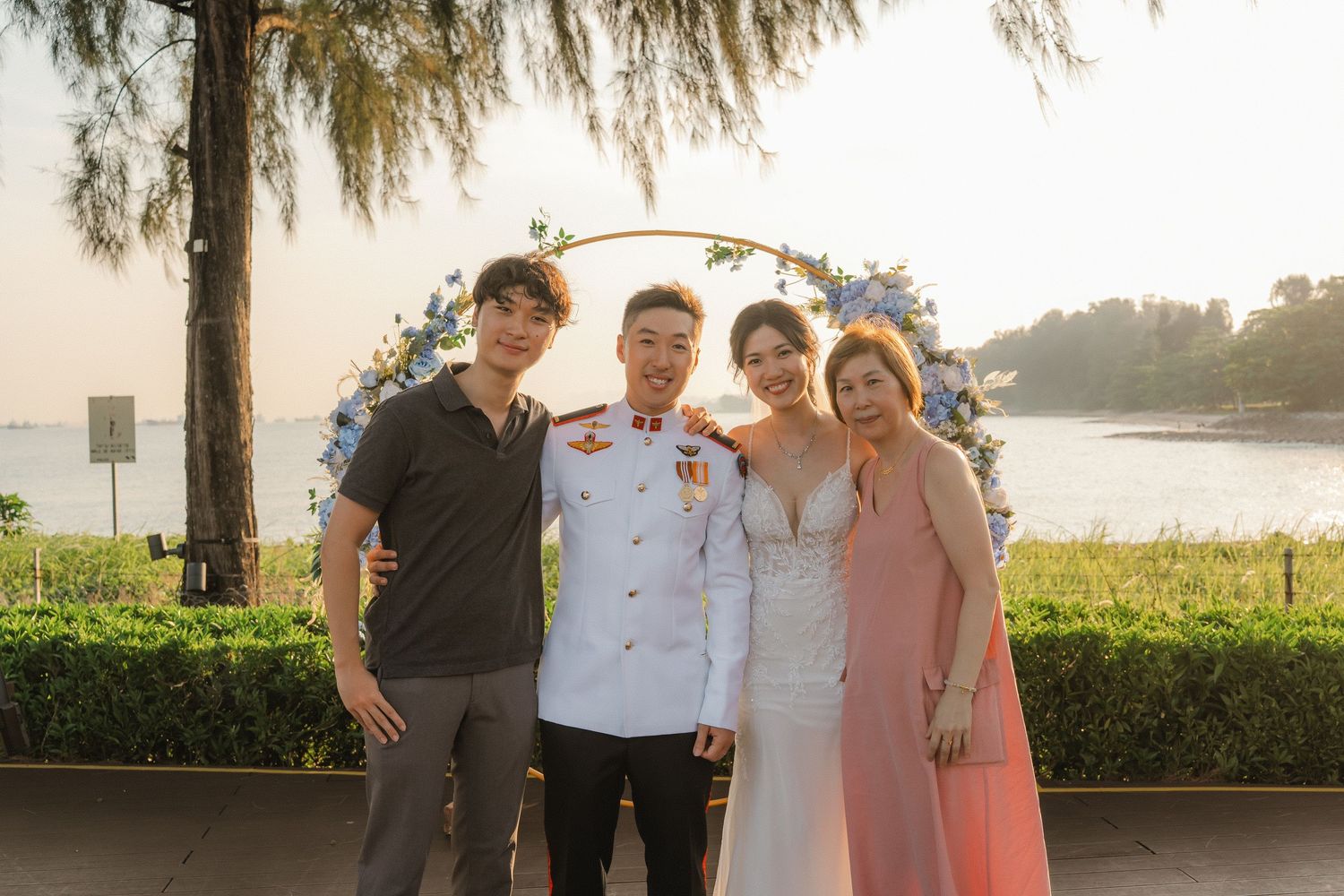 Wedding ceremony setup outdoors with a sunset view and willow trees in the background.