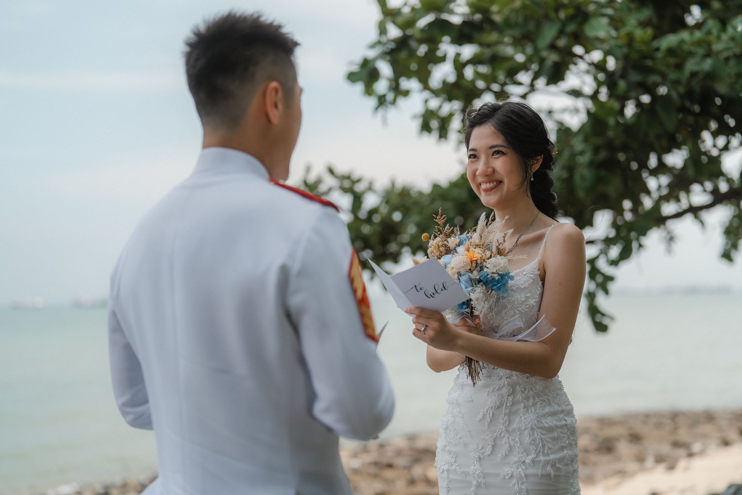 A couple exchanges vows during an intimate beach wedding ceremony near the ocean.