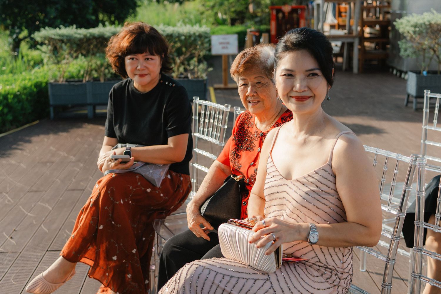 A group of musicians perform together on stringed instruments outdoors on a sunny day.