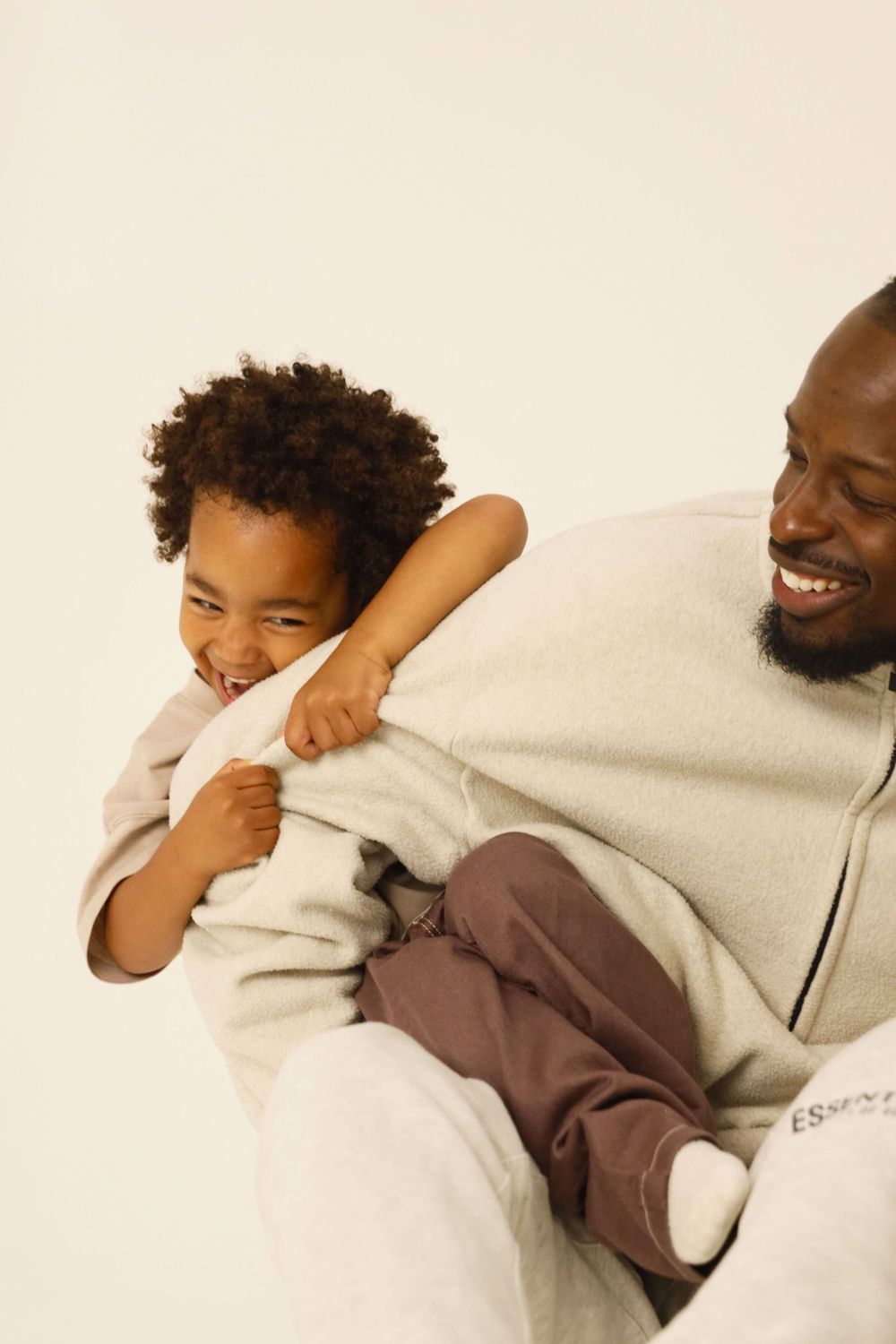 Two people share a joyful moment while relaxing together on a white couch.